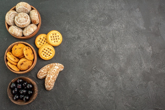 Top view delicious sweet cakes with cookies and olives on dark surface pie sweet cake