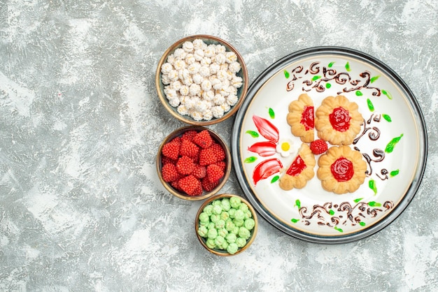 Top view delicious sweet cookies with candies on a white background cake sweet biscuit cookie tea