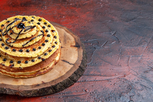 Top view delicious sweet pancakes with icing on dark surface