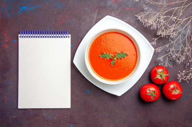 Top view delicious tomato soup tasty dish with single leaf inside plate on the dark background dish sauce tomato color soup meal