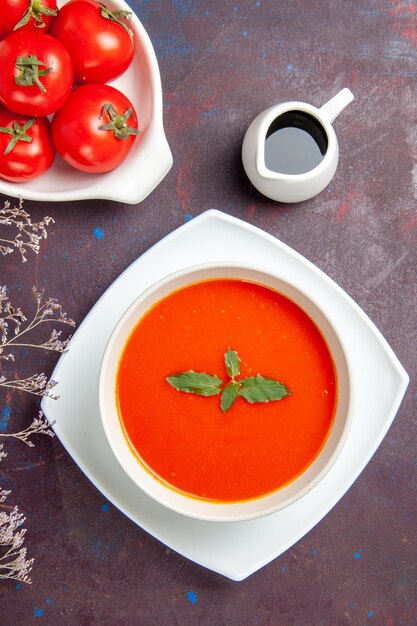 Top view delicious tomato soup with fresh tomatoes on dark background dish meal sauce tomato color soup