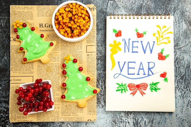 Free photo top view delicious tree biscuits with berries and new year note