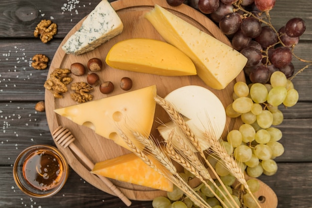 Free photo top view delicious variety of cheese with grapes