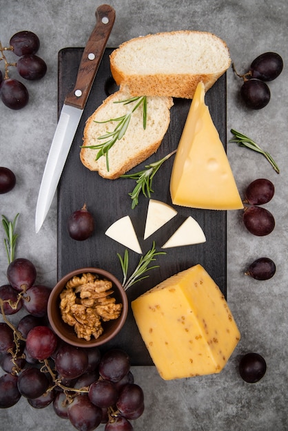 Free Photo top view delicious variety of cheese with walnuts and grapes