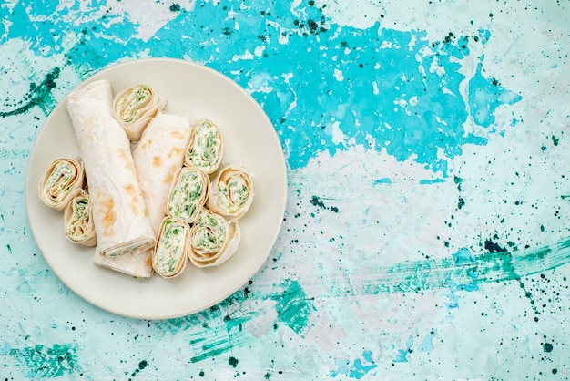 Free Photo top view of delicious vegetable rolls whole and sliced on bright-blue floor food meal roll vegetable snack