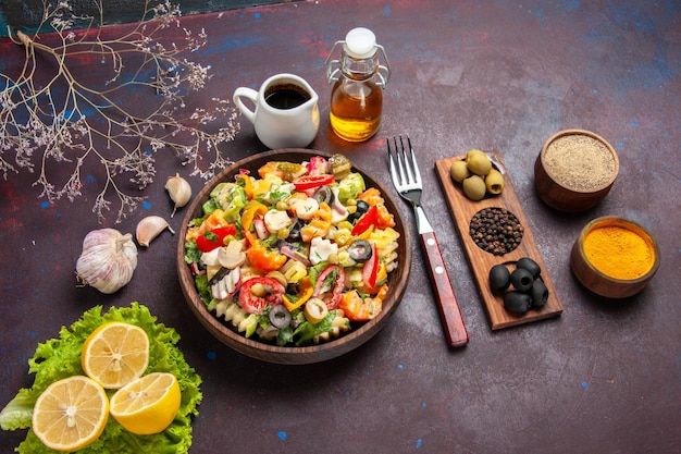 Top view delicious vegetable salad with lemon slices and green salad on a dark background meal diet salad health food