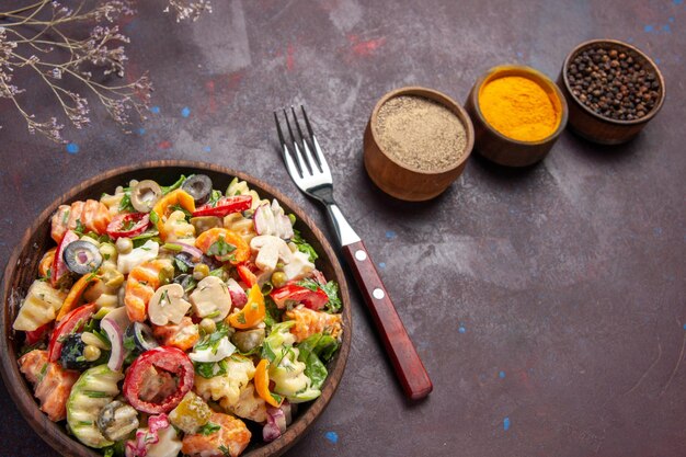 Top view delicious vegetable salad with seasonings on a dark background health diet salad vegetable lunch