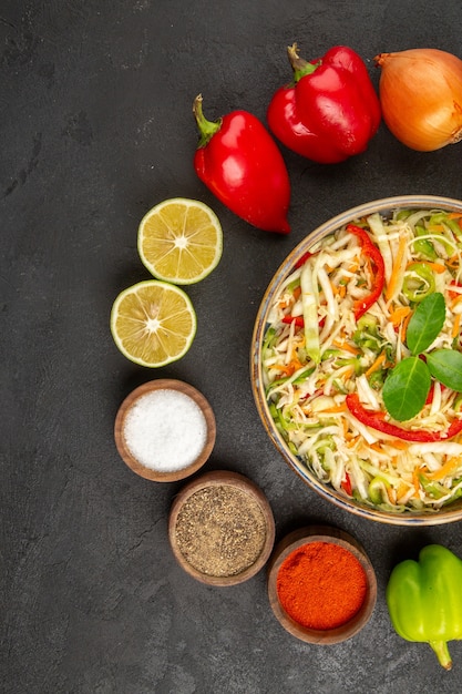 Top view delicious vegetable salad with seasonings and fresh vegetables on grey background