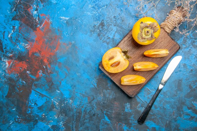 Top view of delicious whole and cut diospyros kaki with knife