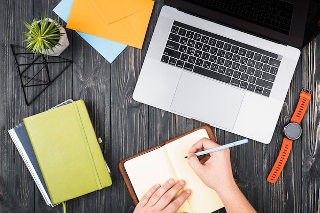 Free Photo top view desk arrangement  with a person writing