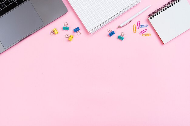 Top view desk concept with pink background