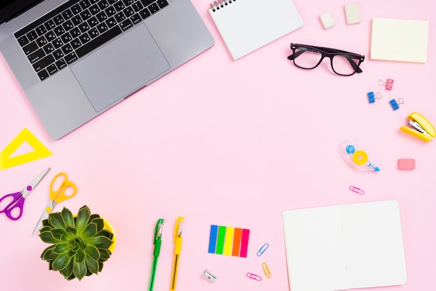 Top view desk concept with pink background