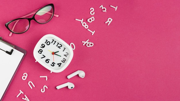 Free Photo top view of desk with clock and glasses