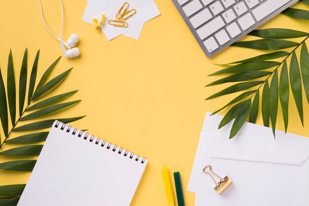 Top view of desk with notebook and leaves