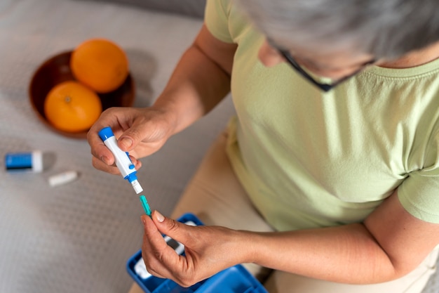 Free Photo top view diabetic woman checking her glucose level