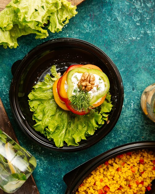 Free photo top view diet food multi-colored bell peppers on lettuce with walnut