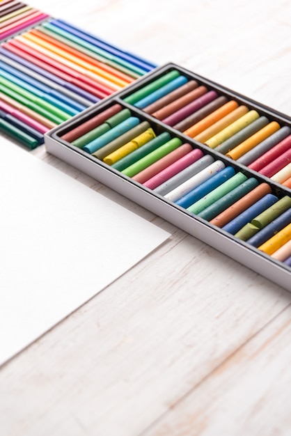 Free photo top view of different colorful pastel paint and markers in boxes on white table