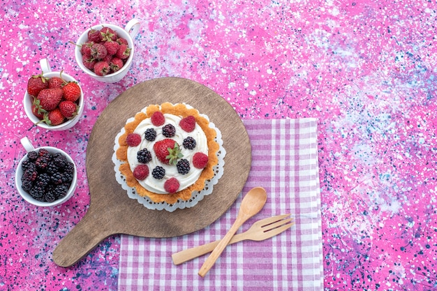 Free photo top view of different delicious cakes with cream and fresh berries on light, berry fruit cake biscuit