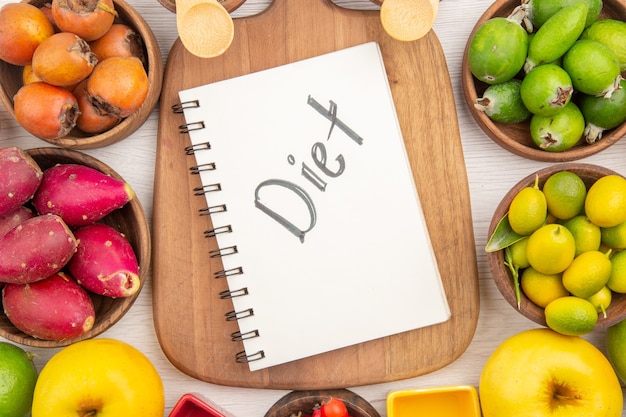 Top view different fresh fruits inside plates on white background tropical ripe color diet exotic healthy life mellow