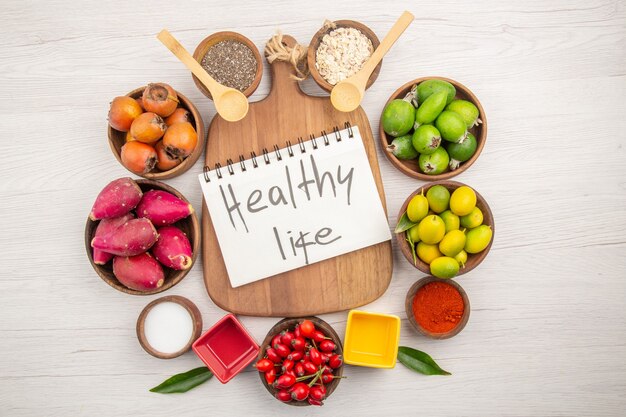 Top view different fresh fruits inside plates on white background tropical ripe diet exotic healthy life