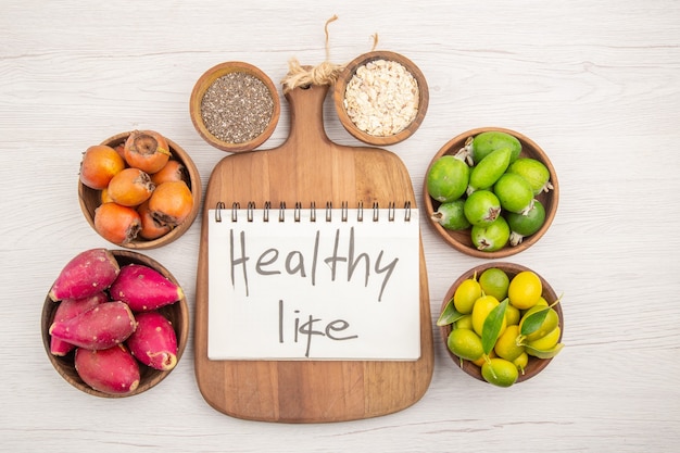 Top view different fresh fruits inside plates on white background tropical ripe healthy life color diet