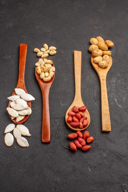 Top view of different fresh nuts on a dark surface