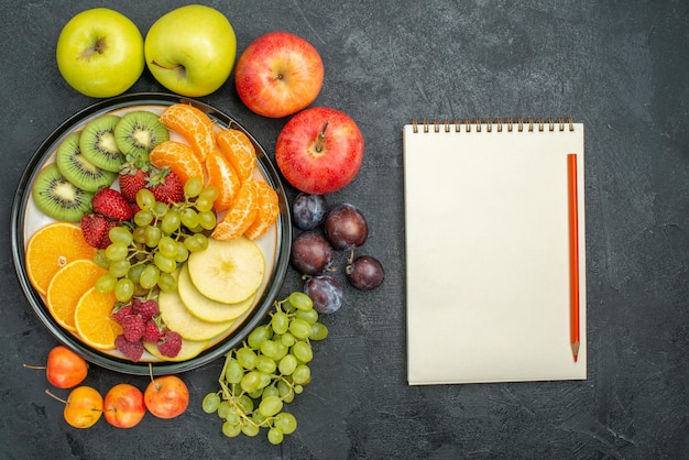 Top view different fruits composition fresh and ripe on dark background mellow fresh fruit health ripe