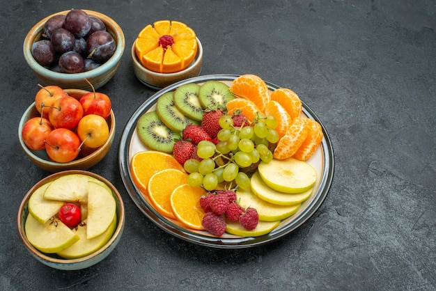 Top view different fruits composition fresh and ripe on a dark background mellow fresh fruits health ripe