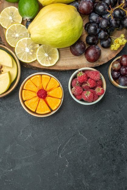 Free photo top view different fruits composition fresh and ripe on the dark-grey background ripe fruits health plant mellow color