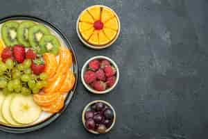 Free photo top view different fruits composition fresh and sliced fruits on dark background health fresh mellow ripe fruits