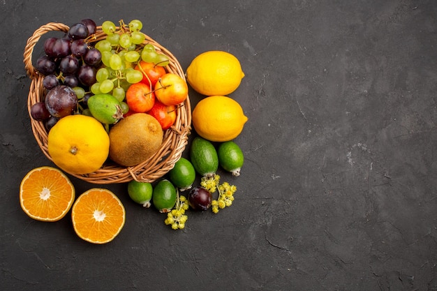 Top view different fruits composition ripe and mellow fruits on dark background diet fruits mellow ripe fresh