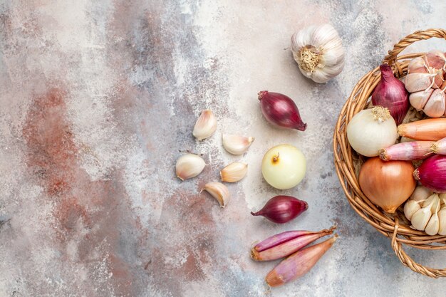 Top view different ingredients onions and garlic inside basket