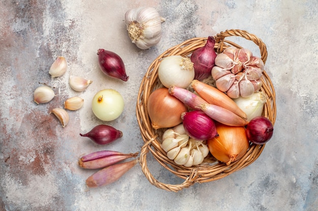 Top view different ingredients onions and garlic inside basket