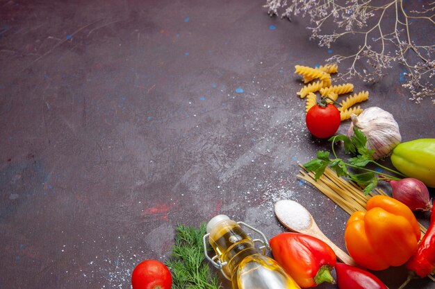 Top view different ingredients raw pasta and fresh vegetables on a dark background product food health salad diet