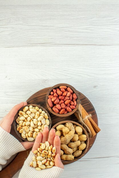 Top view different nuts peanuts hazelnuts and walnuts on white wooden table