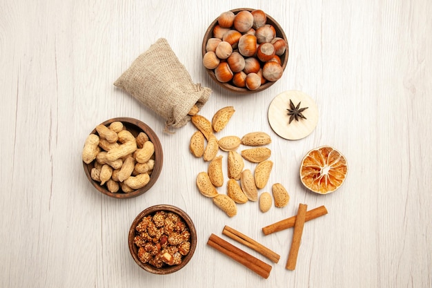 Top view different nuts with cinnamon on the white desk nut snack walnut hazelnut