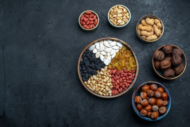 Top view different nuts with raisins and dried fruits on dark-grey background nut snack hazelnut walnut peanut