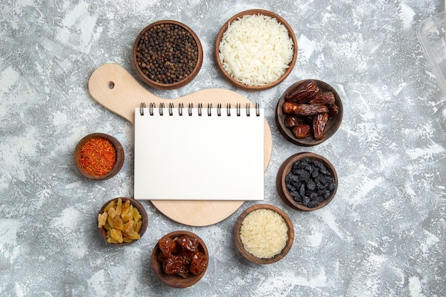 Top view different raisins with seasonings on a white space