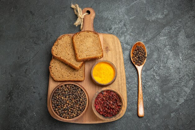 Free Photo top view different seasonings with bread loafs on grey desk bread spicy hot