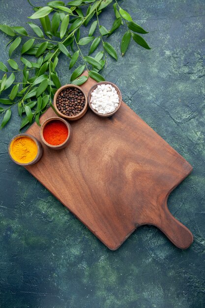 Top view different seasonings with brown wooden desk on dark-blue table color wood sharp tree green kitchen