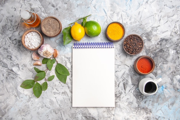 Free Photo top view different seasonings with lemon and garlic on a white table oil spicy fruit salt