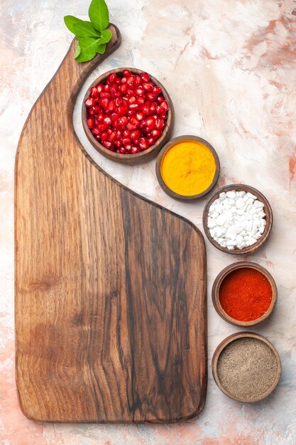 Top view different seasonings with pomegranates on light background