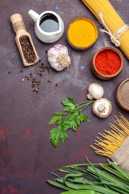 Top view different seasonings with raw pasta and mushrooms on a dark surface product meal food raw