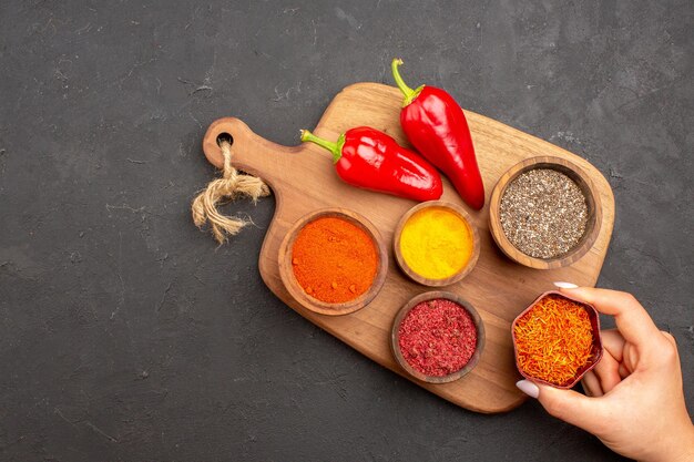 Top view of different seasonings with red pepper on black