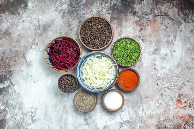 Top view different seasonings with sliced cabbage greens and beet on a white background