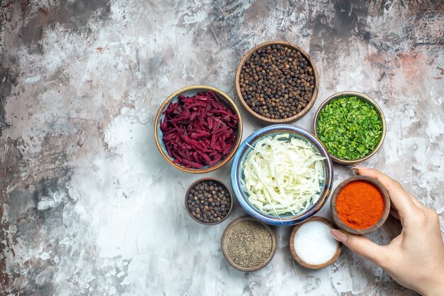 Top view different seasonings with sliced cabbage greens and beet on white background