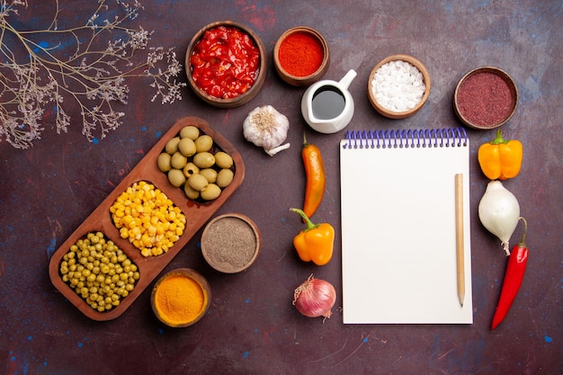 Free Photo top view different seasonings with vegetables on dark space