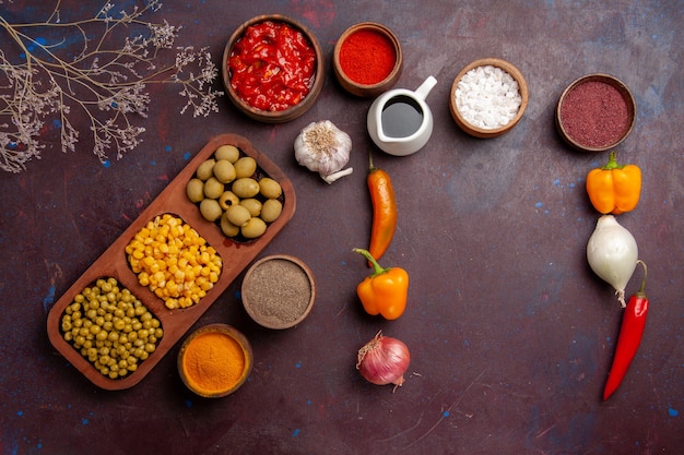 Free photo top view different seasonings with vegetables on dark space