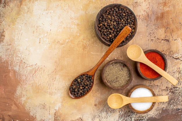 Top view different seasonings on wooden desk