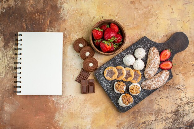 Top view different sweets with cookies and fruits on the light desk